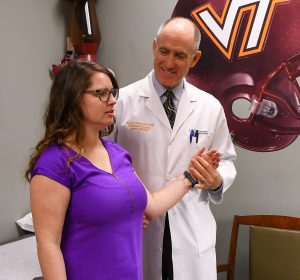 Dr. Haynes checks the shoulder rotation of his patient.