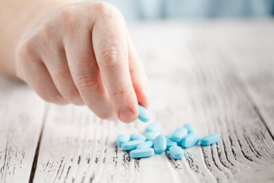 male holding blue pills
